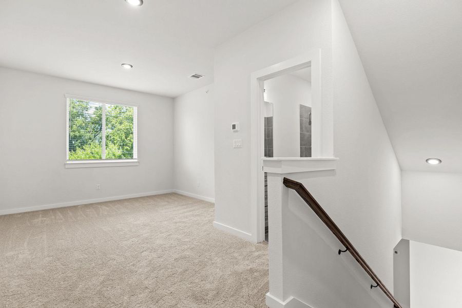 A well-lit upper-level room with soft carpeting and ample natural illumination. A well-lit upper-level room with soft carpeting and ample natural illumination.