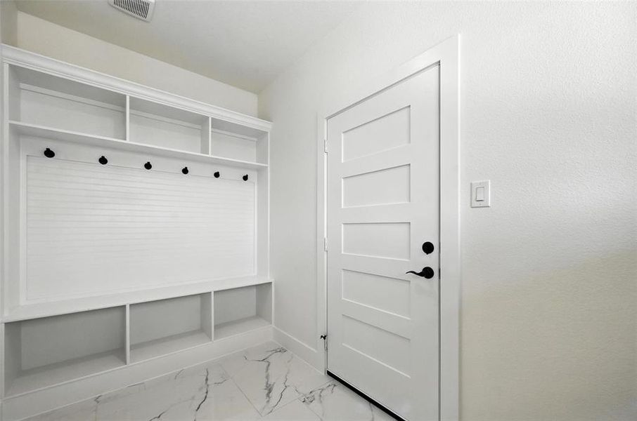 Mudroom with marble finish floors and baseboards