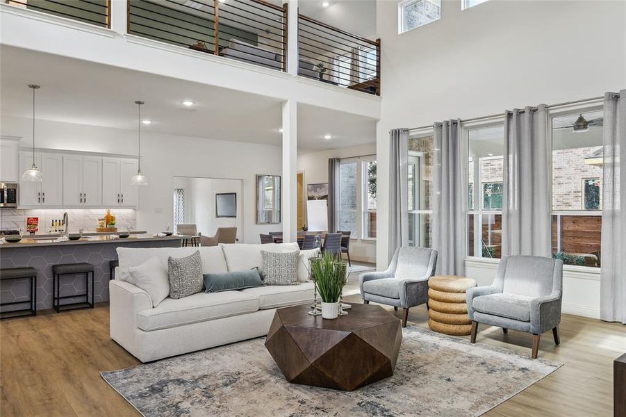 Expansive living area featuring a double-height ceiling, large windows with upper transoms, and wood-finish flooring