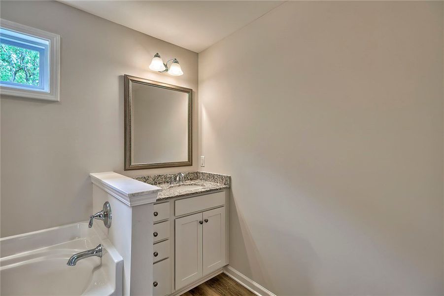This bathroom features a sleek vanity, granite cou