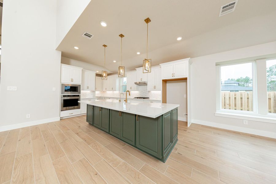 The stunning and generously sized center island features a breakfast bar, perfect for casual dining and entertaining. The island is beautifully designed with pristine quartz countertop and elegant pendant lights.