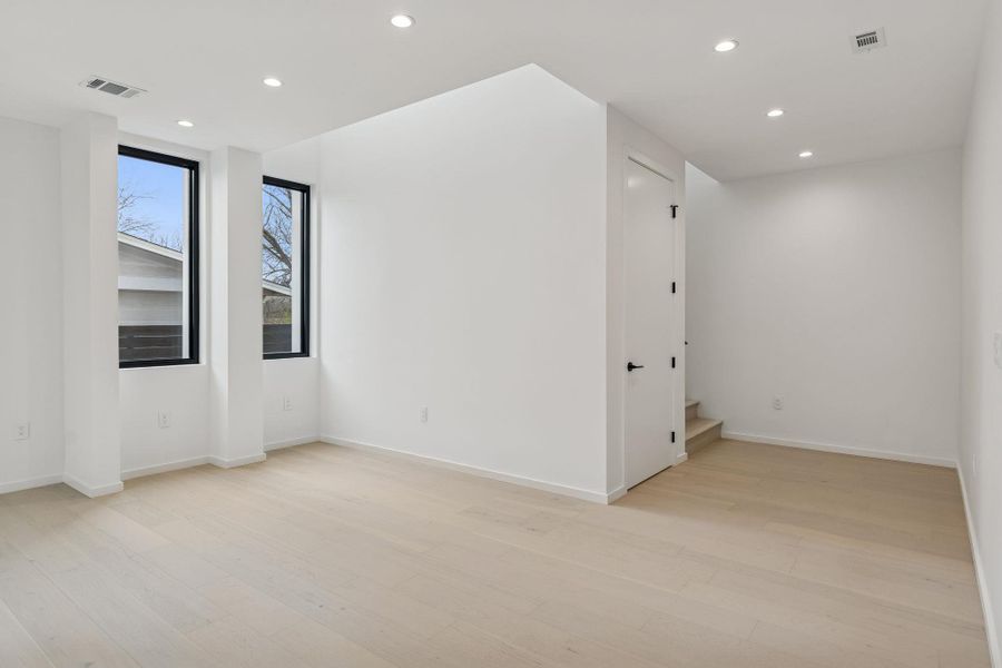 Unfurnished room featuring recessed lighting, light wood finished floors, and stairway