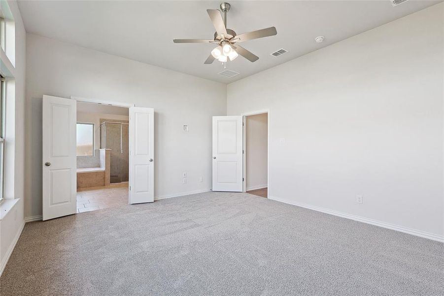 Unfurnished bedroom featuring light carpet and ceiling fan