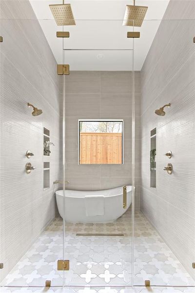 Spacious wet room featuring a freestanding soaking tub, dual rain showerheads, and dual wall-mounted shower fixtures