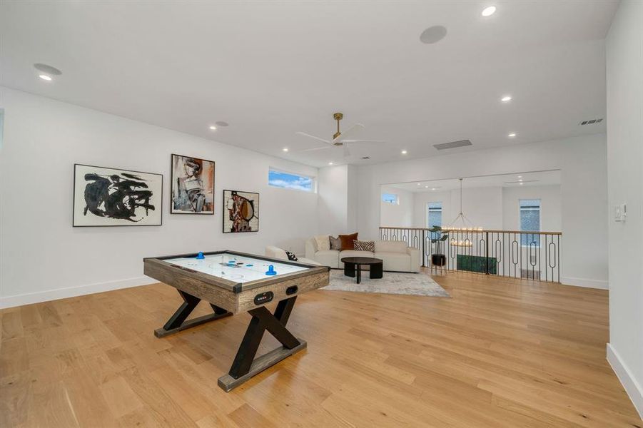 Recreation room with light wood-style flooring, recessed lighting, and a ceiling fan Recreation room with light wood-style flooring, recessed lighting, and a ceiling fan