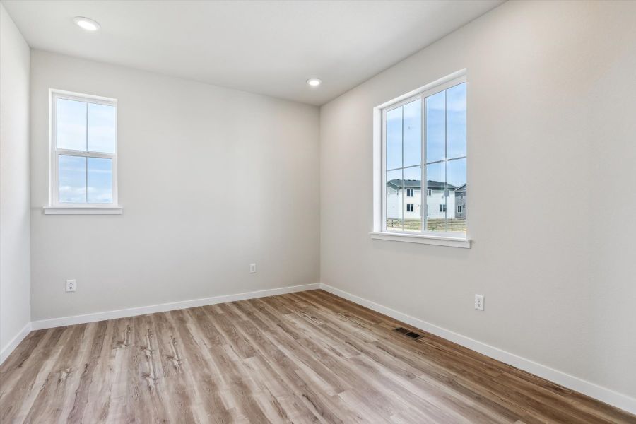 A room with a wood floor and windows.