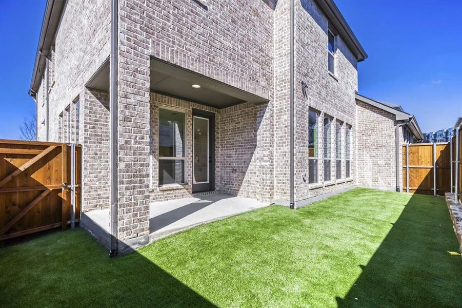 View of exterior entry with a gate, a patio area, and brick siding