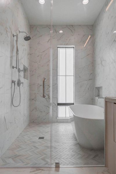 Spacious walk-in shower featuring full-height marble-look tile, frameless glass enclosure, rain shower head, handheld fixture, and built-in niche for storage. Natural light filters through a tall window, enhancing the bright, sophisticated design of this spa-inspired bath.