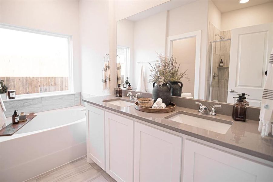 Bathroom featuring a garden tub, a shower stall, and double vanity Bathroom featuring a garden tub, a shower stall, and double vanity