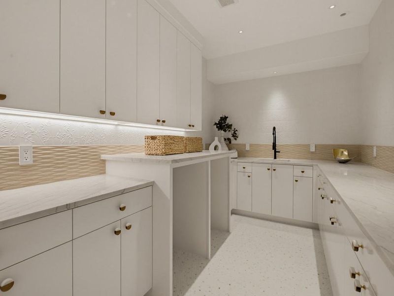 Spacious utility room featuring extensive white cabinetry, light-toned countertops, and a built-in sink with a matte black faucet