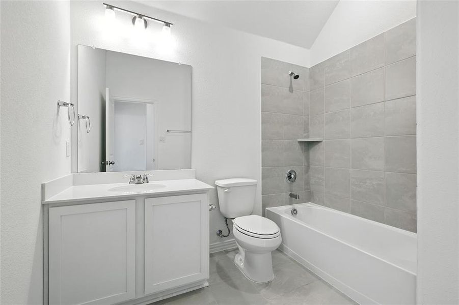 Full bathroom with vanity, washtub / shower combination, and vaulted ceiling