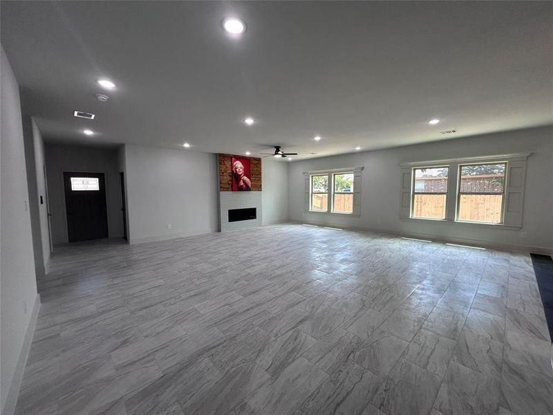 Unfurnished living room with recessed lighting, ceiling fan, and a fireplace Unfurnished living room with recessed lighting, ceiling fan, and a fireplace