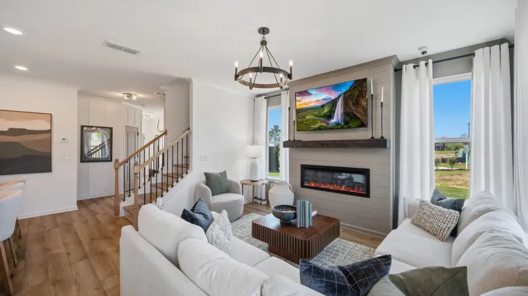 Open family living space with electric fireplace and modern finishes in Langley Overlook new construction townhome.