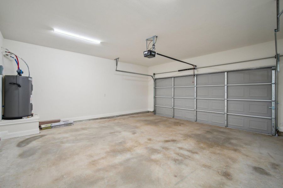 Garage featuring water heater and a garage door opener Garage featuring water heater and a garage door opener