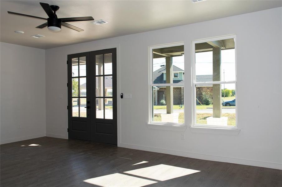 Doorway to outside with ceiling fan, wood finished floors, and french doors Doorway to outside with ceiling fan, wood finished floors, and french doors
