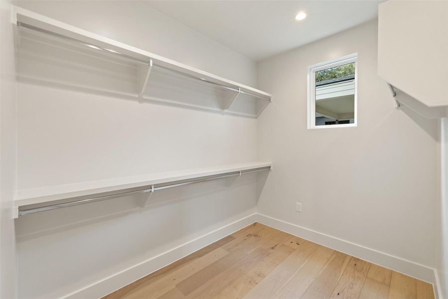 Walk in closet with wood-type flooring