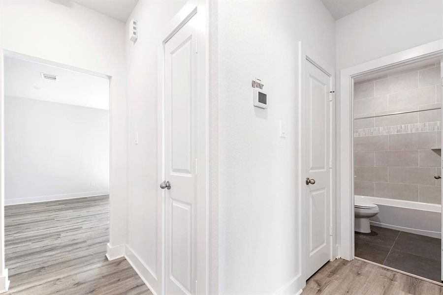 Picture shows hallway coming off family room, leading to secondary bedrooms (split floorplan).  Doors included are the coat closet and linen closet for secondary bathroom.