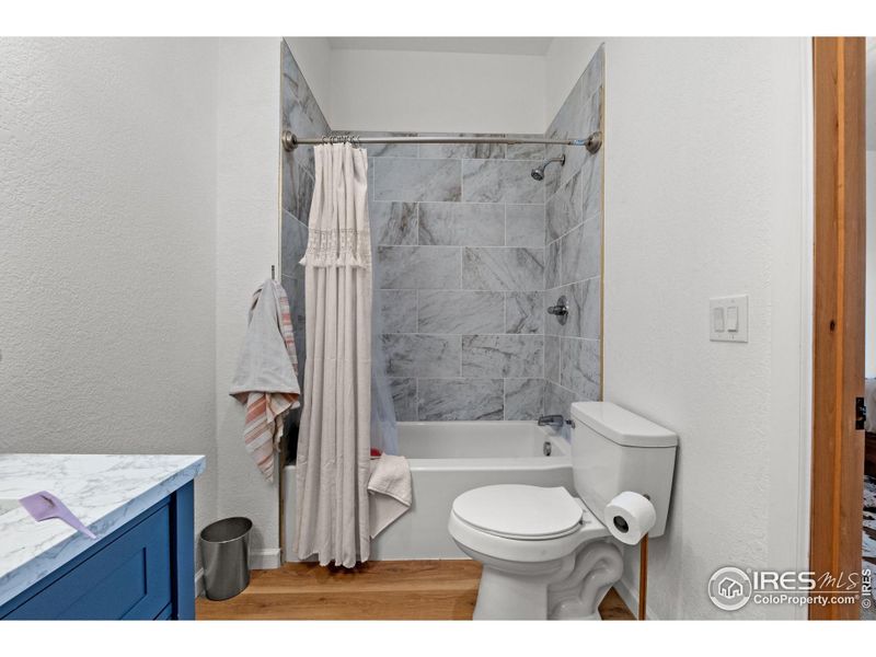 Modern ensuite bathroom with sleek finishes, full shower/tub combination, and a bright, clean design to complement the private bedroom retreat