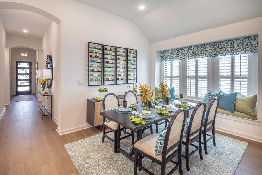 Dining room with baseboards, arched walkways, wood finished floors, and vaulted ceiling