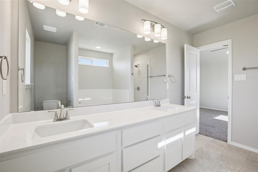 Full bath with double vanity and a stall shower