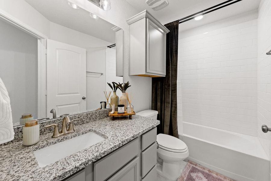 Full bathroom with shower / bath combo with shower curtain and vanity
