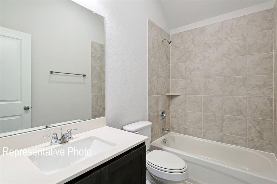 Full bathroom with vanity, tiled shower / bath combo, and toilet