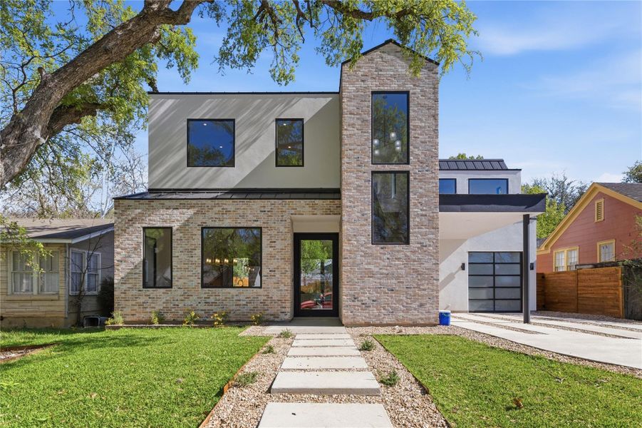 Modern facade showcasing light-colored brick and expansive dark-trimmed windows on a well-manicured lawn. Modern facade showcasing light-colored brick and expansive dark-trimmed windows on a well-manicured lawn.