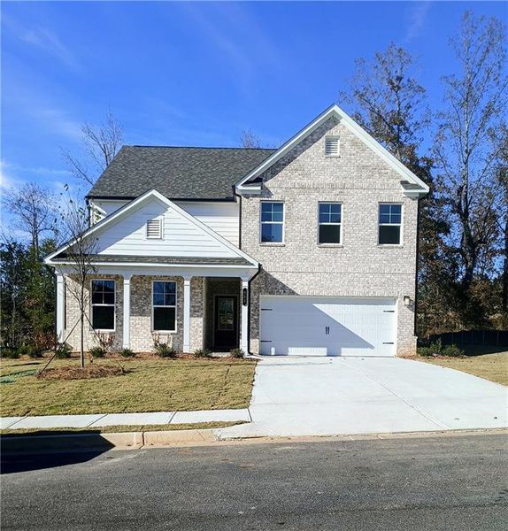 Front exterior of a new home in River Oaks, Locust Grove, GA, highlighting curb appeal (Image 1).