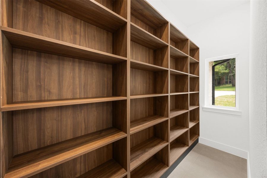 Oversized walk-in pantry with extensive custom designed shelving and abundant storage space.