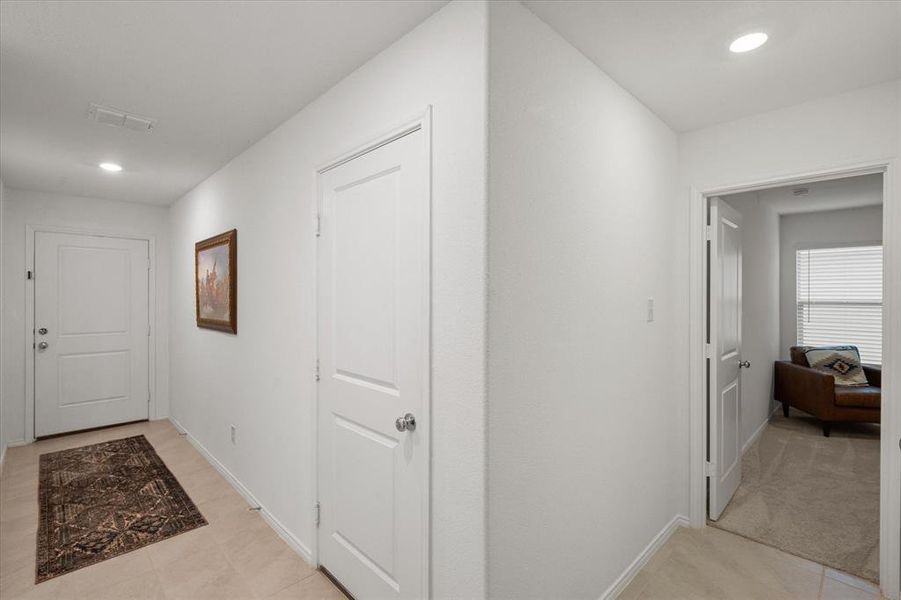 Hallway featuring recessed lighting and light tile patterned floors