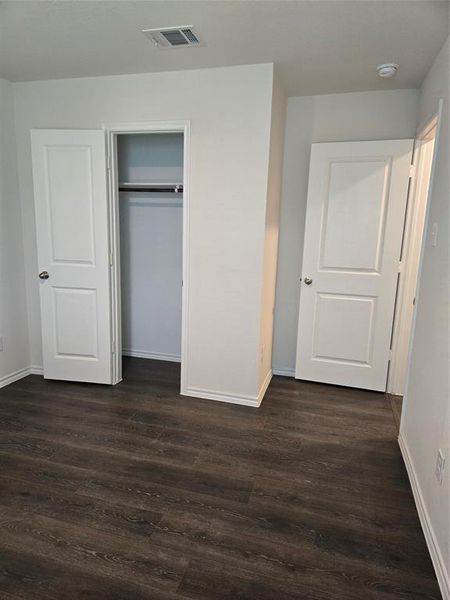 Unfurnished bedroom with a closet and dark hardwood / wood-style floors