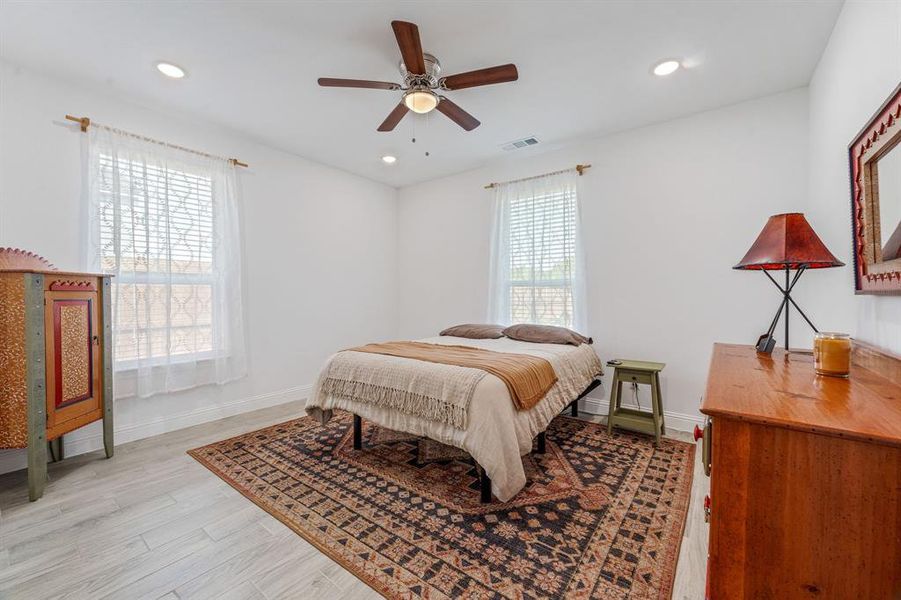 Bedroom featuring multiple windows, light wood-style floors, recessed lighting, and a ceiling fan