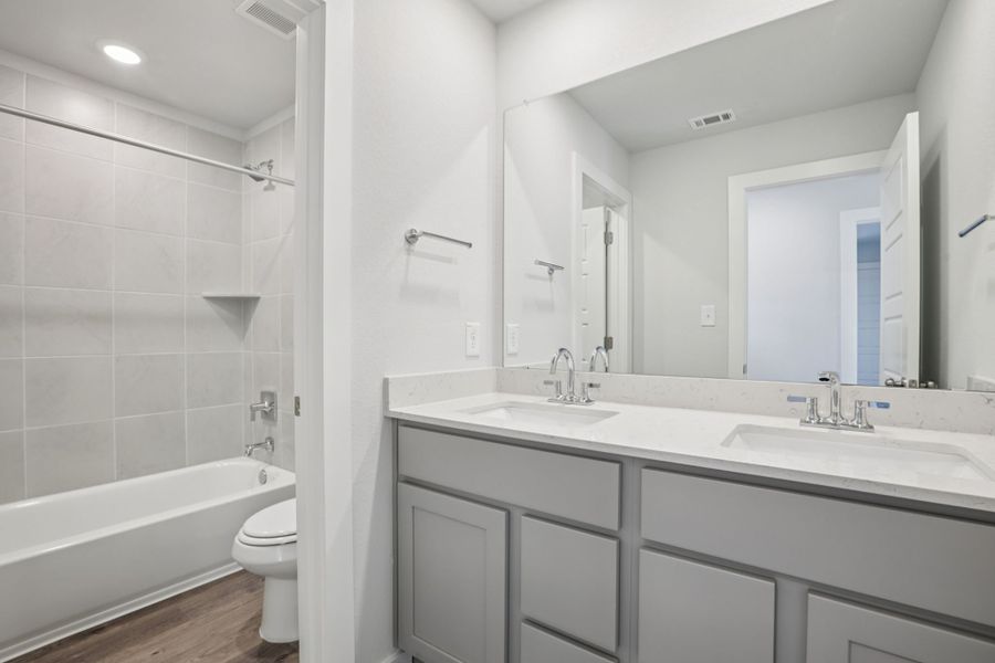 A bathroom with a tub sink and toilet.