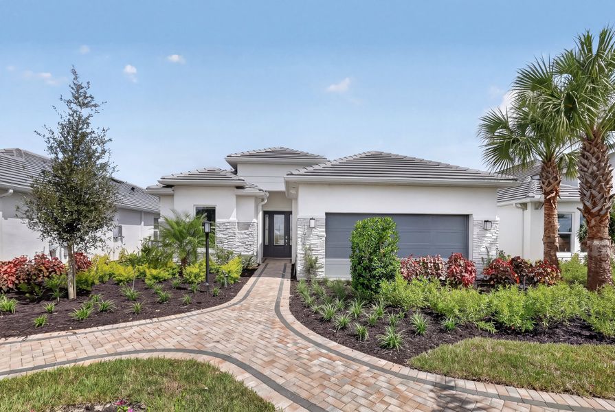 Front exterior of a new home in Esplanade at Kingston, Estero, FL, highlighting curb appeal (Image 19).