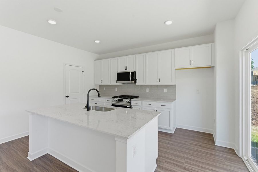 A kitchen with white cabinets.