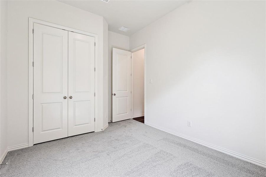 Unfurnished bedroom with a closet and light carpet