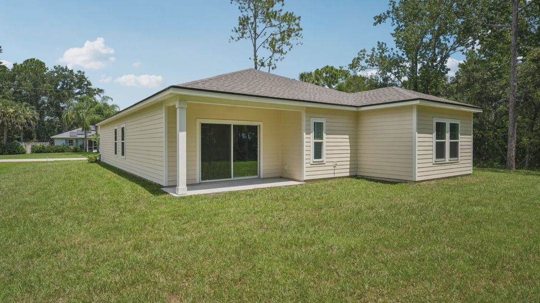 Exquisite beige siding and covered patio enhance this Palm Coast residence's luxurious outdoor allure.