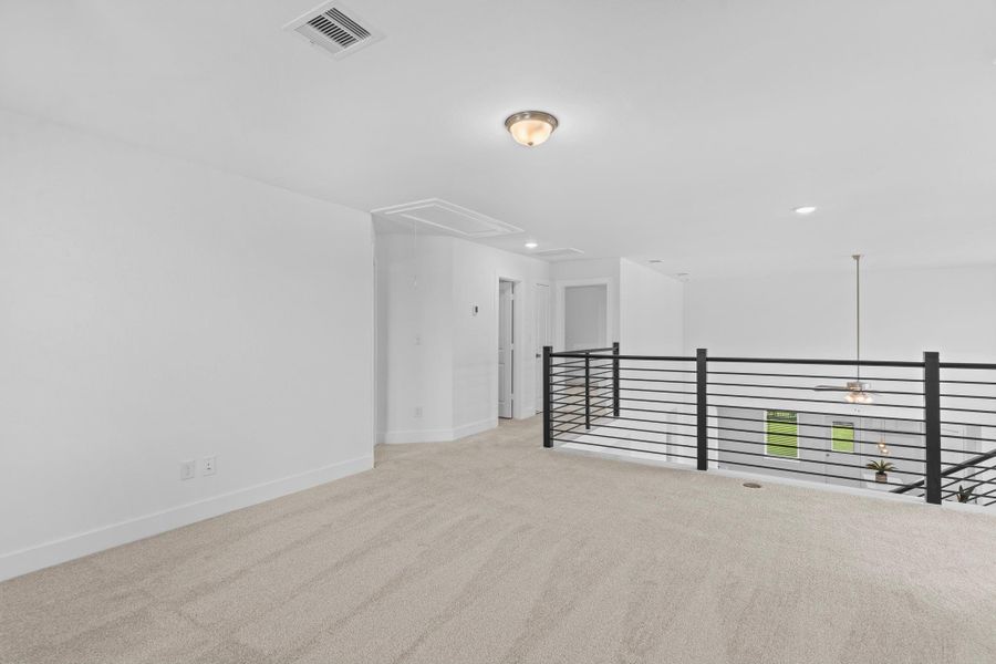 Another view of the game room showcases its open connection to the upstairs hallway, modern wrought iron railing, and the airy overlook to the first floor—perfect for staying connected while enjoying a private upstairs retreat. **Image Representative of Plan Only and May Vary as Built**.