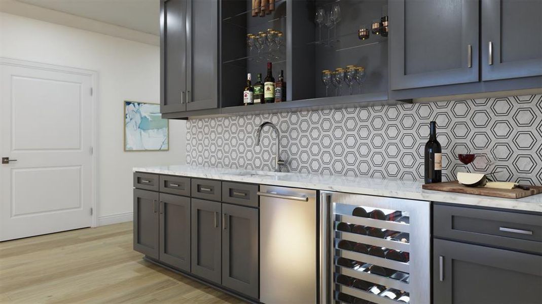 Bar with light wood-type flooring, light stone counters, tasteful backsplash, and sink