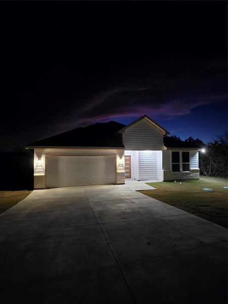 Picture of nighttime clouds above the house with all the lights on outside of house.
