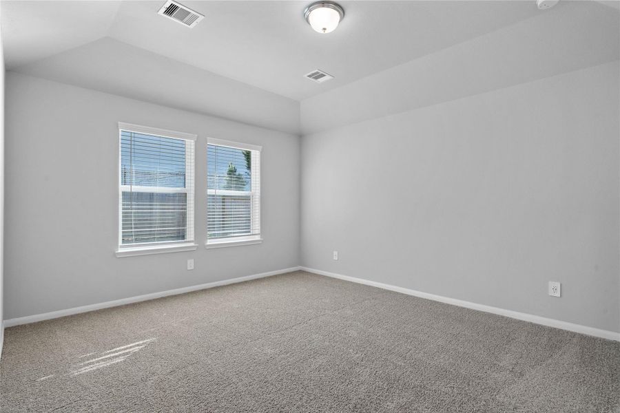 The primary bedroom provides a peaceful escape with a bright, neutral palette, sloped ceilings, large windows, and plush carpet flooring, creating a calm and restorative atmosphere to end your day. The primary bedroom provides a peaceful escape with a bright, neutral palette, sloped ceilings, large windows, and plush carpet flooring, creating a calm and restorative atmosphere to end your day.