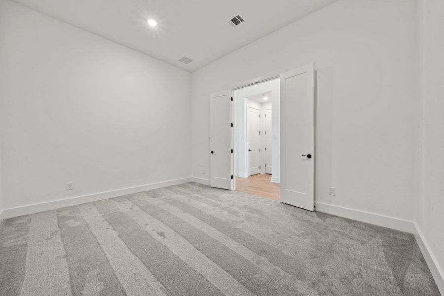 Unfurnished room with light colored carpet and recessed lighting