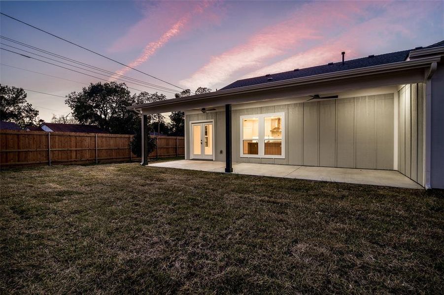 Back house at dusk with a patio area and a yard