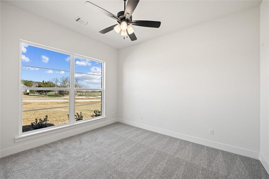 Empty room featuring light carpet and a ceiling fan