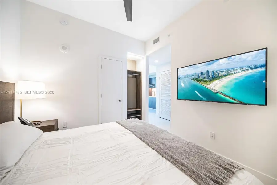 Room interior featuring high ceilings, ceiling fan, walk-in closet with built-in shelving, and recessed lighting