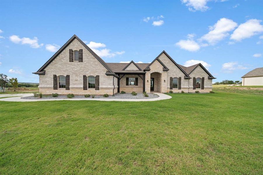 French country home featuring a front lawn