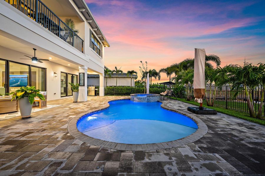 Extended pool deck, spa, and waterfall feature.