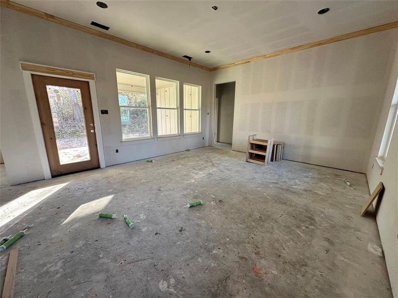 Unfurnished living room featuring ornamental molding