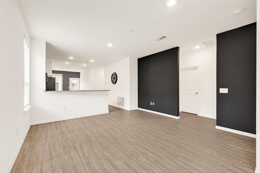 Clean minimalist hallway showcasing crisp white walls, dark doors, and modern light fixtures.