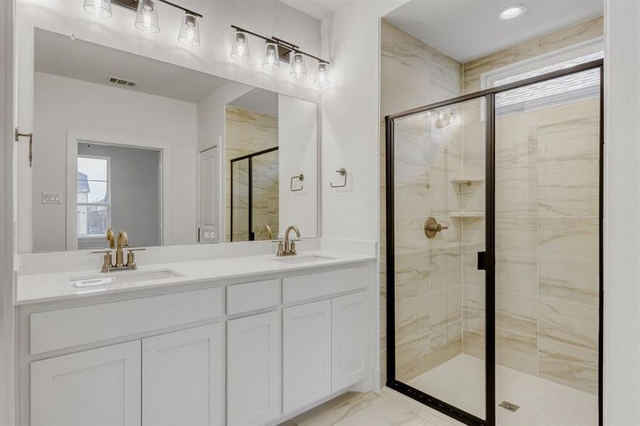 Bathroom with double vanity, a marble finish shower, light marble finish floors, and recessed lighting Bathroom with double vanity, a marble finish shower, light marble finish floors, and recessed lighting